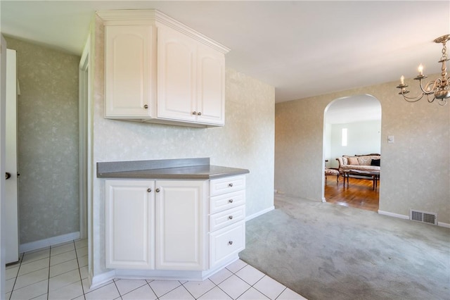 1936 Sylvan Ave, Latrobe, PA 15650 - kitchen featuring arched walkways, white cabinets, a chandelier, and light carpet