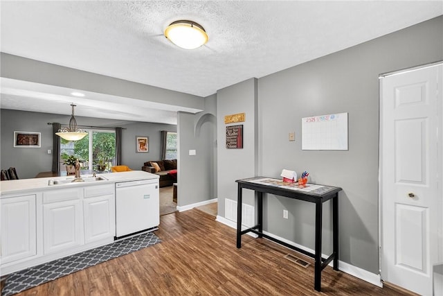 847 Sunset Cir, Cranberry Twp, PA 16066 - kitchen featuring dark wood-style flooring, arched walkways, white dishwasher, white cabinets, and a textured ceiling