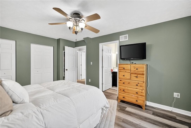 847 Sunset Cir, Cranberry Twp, PA 16066 - bedroom with light wood-type flooring, multiple closets, connected bathroom, and a ceiling fan