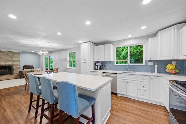 215 E Edgewood Dr, Peters Twp, PA 15317 - kitchen featuring a breakfast bar area, light wood finished floors, recessed lighting, light countertops, and a center island
