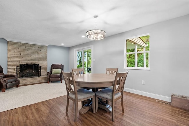 215 E Edgewood Dr, Peters Twp, PA 15317 - dining room with wood finished floors, a chandelier, a stone fireplace, and recessed lighting
