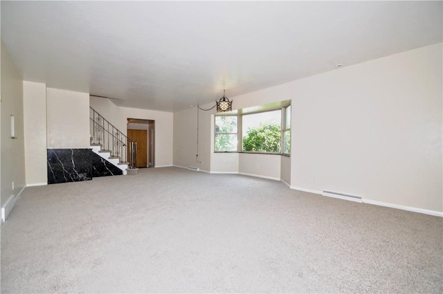 306 Barbara Dr, Carroll Twp, PA 15063 - unfurnished living room with carpet, stairs, and a chandelier