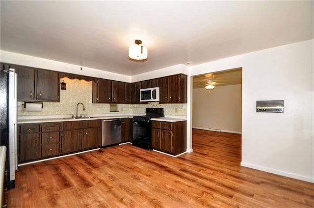 306 Barbara Dr, Carroll Twp, PA 15063 - kitchen with white appliances, light countertops, dark brown cabinets, wood finished floors, and backsplash