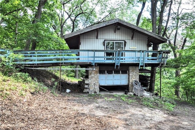 306 Barbara Dr, Carroll Twp, PA 15063 - view of front of property with a garage, a deck, dirt driveway, and stone siding