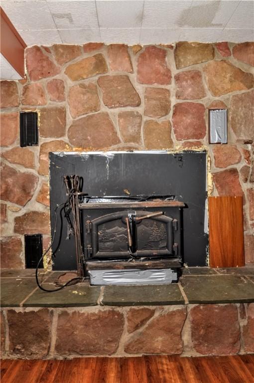 306 Barbara Dr, Carroll Twp, PA 15063 - detailed view of a wood stove, wood finished floors, and a paneled ceiling