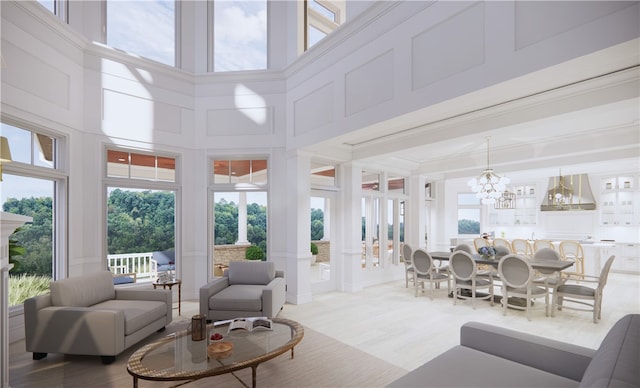 85 1st St, Oakmont, PA 15139 - living area with a high ceiling, a chandelier, a decorative wall, plenty of natural light, and light wood-style flooring