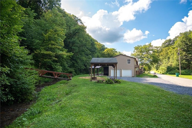 151 Cove Run Rd, Bradys Bend Twp, PA 16028 - view of grassy yard featuring driveway, a garage, and a forest view