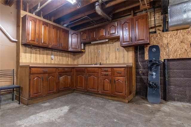 151 Cove Run Rd, Bradys Bend Twp, PA 16028 - kitchen with unfinished concrete floors, light countertops, brown cabinetry, and wood walls