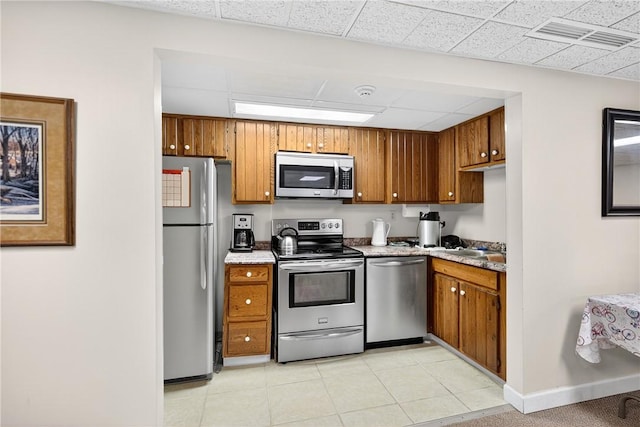 820 E Beau St Unit Tlc, South Strabane, PA 15301 - kitchen featuring appliances with stainless steel finishes, brown cabinets, light countertops, a drop ceiling, and light tile patterned floors