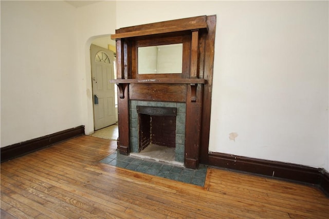 431 1st Ave, Luzerne Twp, PA 15413 - unfurnished living room with hardwood / wood-style flooring, a tile fireplace, and arched walkways