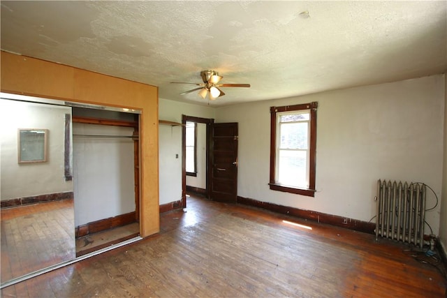 431 1st Ave, Luzerne Twp, PA 15413 - unfurnished bedroom with radiator heating unit, hardwood / wood-style flooring, a closet, a ceiling fan, and a textured ceiling