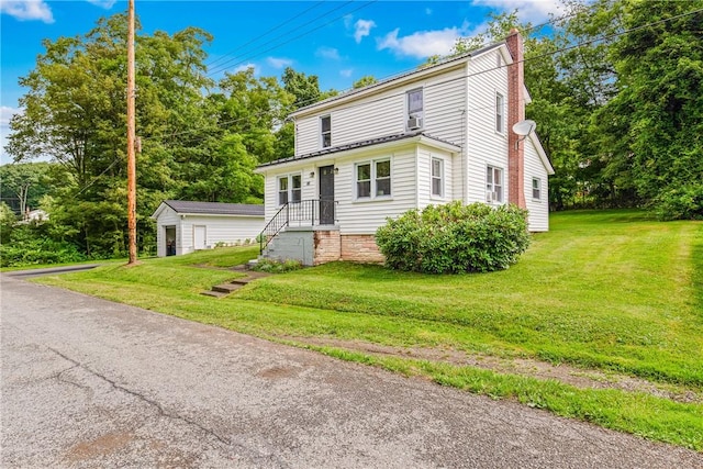 136 B St, Shade Twp, PA 15563 - view of front of house featuring a chimney, a front lawn, and an outbuilding
