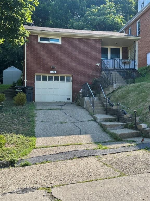 424 Wilson Ave, Harmony Twp, PA 15003 - view of side of property featuring concrete driveway, a garage, brick siding, and stairway