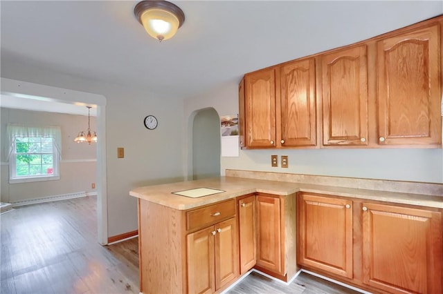 1405 Three Degree Rd, Adams Twp, PA 16059 - kitchen featuring arched walkways, a peninsula, light countertops, light wood-type flooring, and baseboard heating