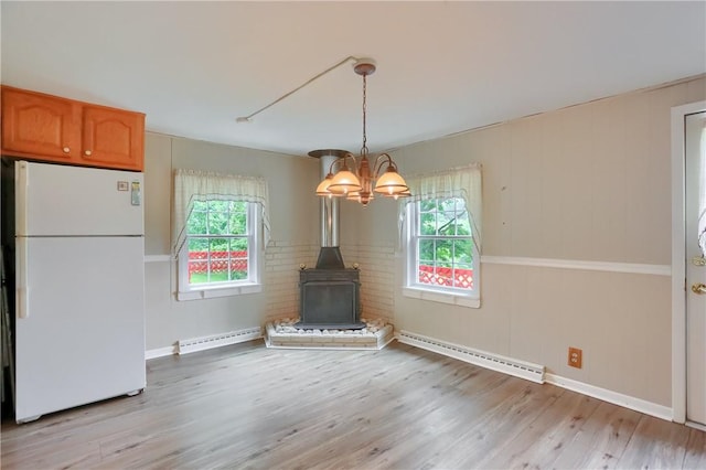 1405 Three Degree Rd, Adams Twp, PA 16059 - unfurnished dining area featuring baseboard heating, light wood-type flooring, a chandelier, and a wood stove