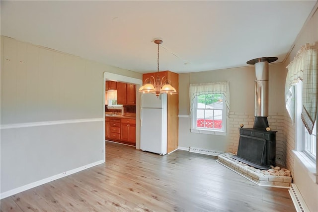 1405 Three Degree Rd, Adams Twp, PA 16059 - unfurnished dining area with a wood stove, a chandelier, a baseboard radiator, and light wood finished floors