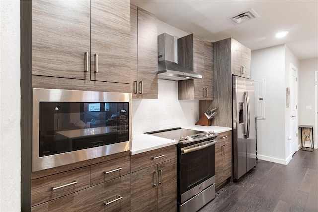 2545 Penn Ave Unit 208, Downtown Pgh, PA 15222 - kitchen featuring appliances with stainless steel finishes, wall chimney range hood, dark wood-type flooring, backsplash, and modern cabinets