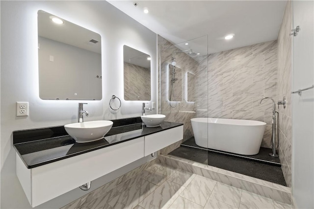 2545 Penn Ave Unit 208, Downtown Pgh, PA 15222 - full bathroom with marble look tiles, a freestanding bath, double vanity, recessed lighting, and a walk in shower