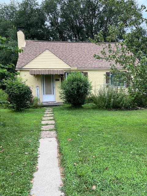 611 Maplehurst Dr N, Versailles, PA 15137 - view of front of property featuring a front yard, brick siding, a chimney, and a shingled roof