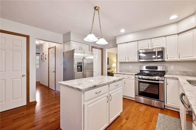103 Cool Springs Ln, Penn Twp, PA 15636 - kitchen featuring stainless steel appliances, white cabinetry, a center island, light stone countertops, and light wood finished floors
