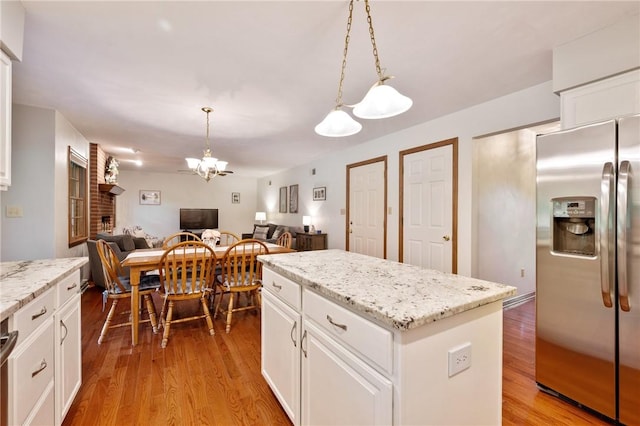 103 Cool Springs Ln, Penn Twp, PA 15636 - kitchen with stainless steel fridge, open floor plan, a chandelier, a kitchen island, and light wood-style flooring