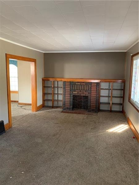 unfurnished living room with light carpet, ornamental molding, and a brick fireplace