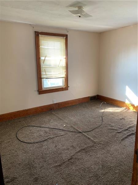 empty room featuring carpet floors and ceiling fan