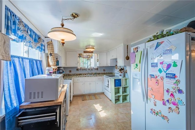 kitchen with white appliances, white cabinets, sink, and light tile floors