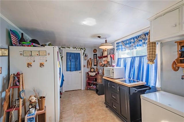 kitchen featuring hanging light fixtures, white appliances, white cabinetry, and light tile floors