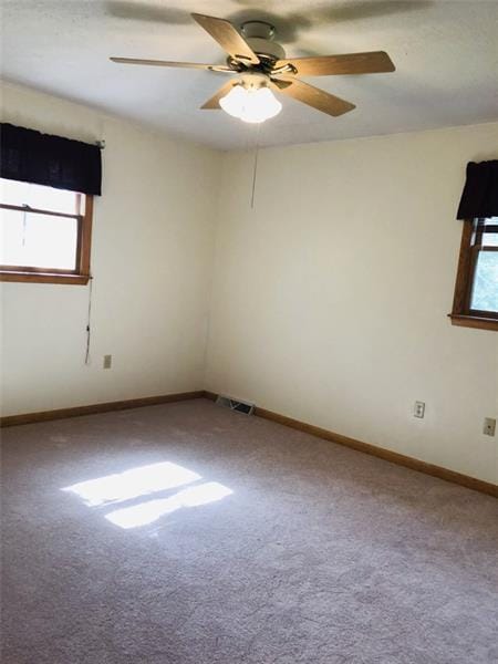 empty room with ceiling fan and carpet