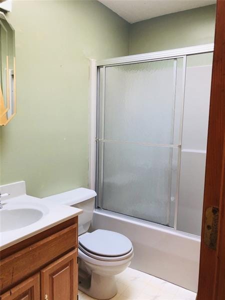 full bathroom featuring toilet, vanity, bath / shower combo with glass door, and tile flooring