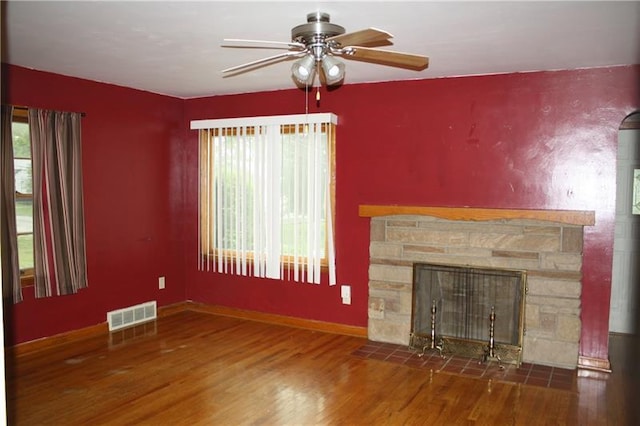 unfurnished living room featuring a healthy amount of sunlight, ceiling fan, and dark hardwood / wood-style flooring