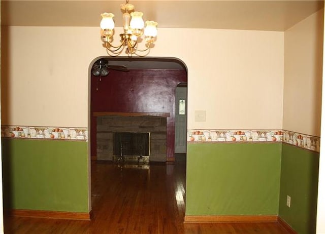 corridor with an inviting chandelier and dark wood-type flooring