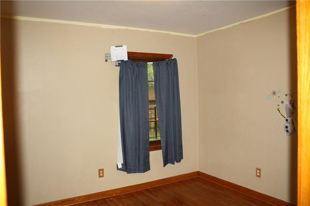 unfurnished room with dark wood-type flooring and ornamental molding