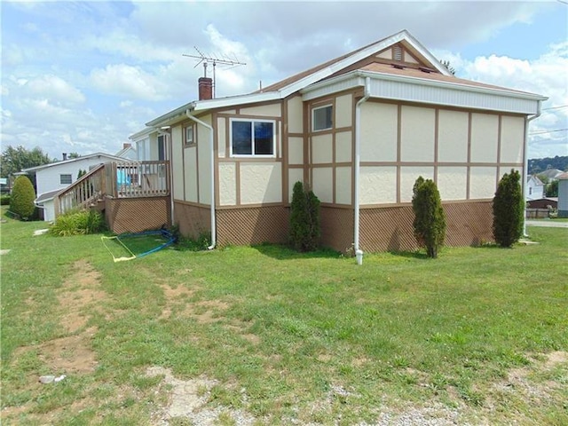 view of property exterior featuring a wooden deck and a yard