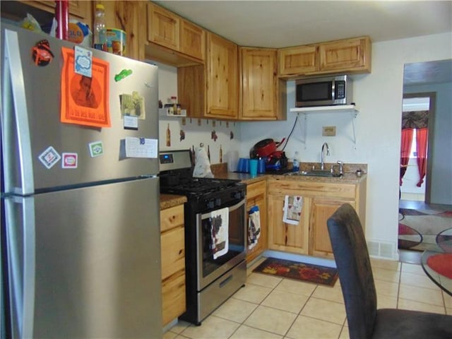 kitchen featuring appliances with stainless steel finishes, sink, and light tile floors