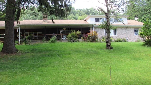 rear view of property featuring a lawn