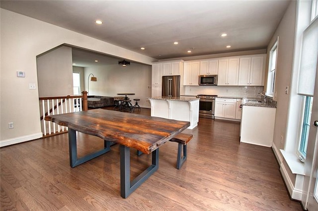 dining room with dark hardwood / wood-style floors, sink, and a wealth of natural light