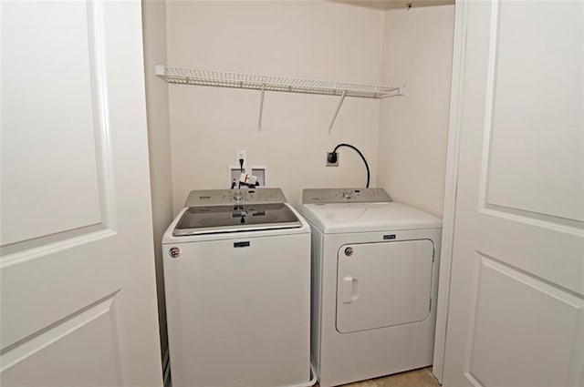 clothes washing area with washer hookup, hookup for an electric dryer, and washer and dryer