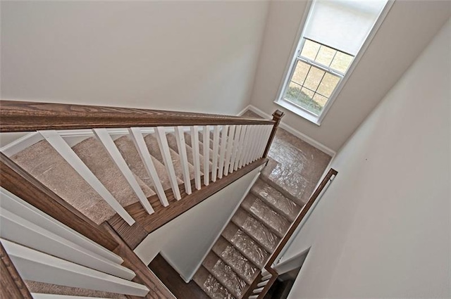 staircase featuring a towering ceiling