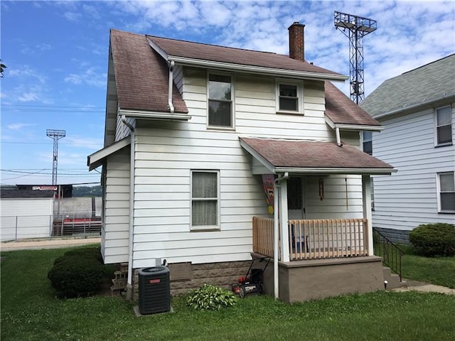 back of property featuring central AC unit and a lawn