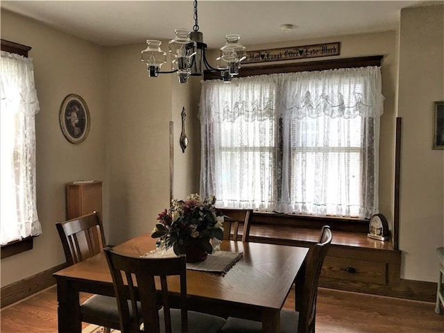 dining space featuring hardwood / wood-style floors and an inviting chandelier