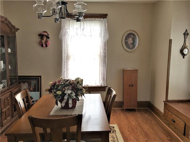 dining area featuring dark wood-type flooring and a chandelier