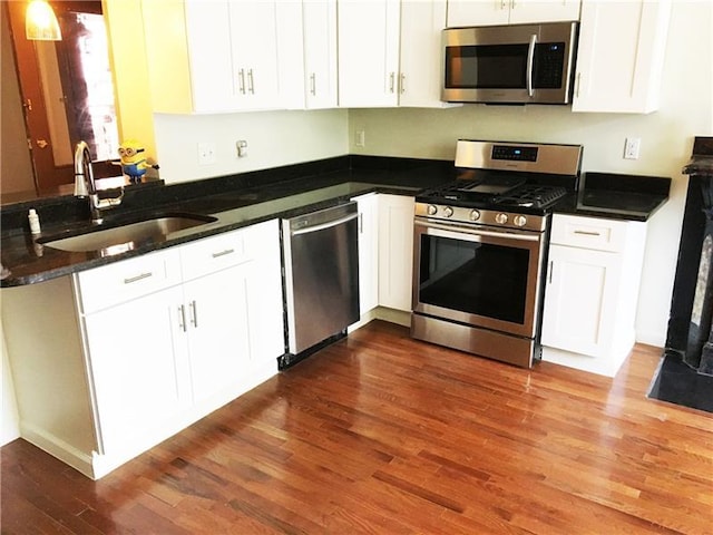 kitchen with white cabinets, stainless steel appliances, dark hardwood / wood-style floors, and sink