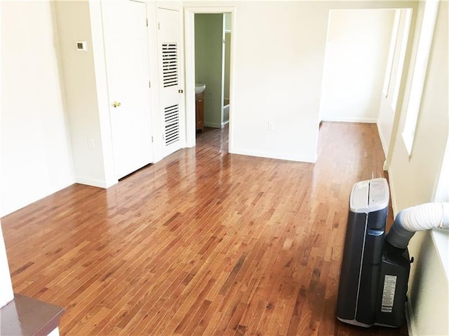 bedroom featuring a closet, ensuite bathroom, and light hardwood / wood-style flooring