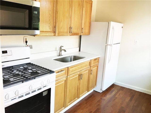 kitchen with dark wood-type flooring, white appliances, and sink