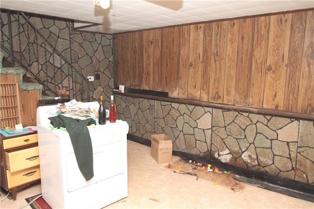 basement with washer / clothes dryer and wooden walls