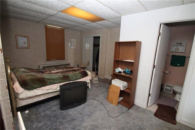 bedroom featuring a paneled ceiling, light colored carpet, and radiator heating unit