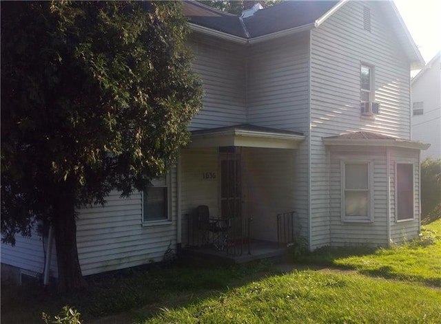 rear view of property featuring a lawn