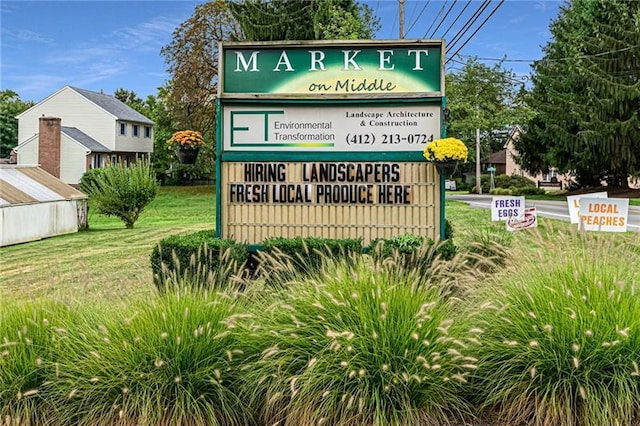 community / neighborhood sign featuring a yard